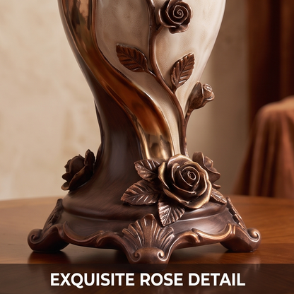 CASNELA exquisite rose detail — base close-up showing ornate scrollwork feet, full rose blooms and trailing vine stem in deep antique bronze
