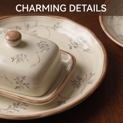 CASNELA stacked plates and bowls in two sizes showing warm brown rim and hand-painted botanical pattern